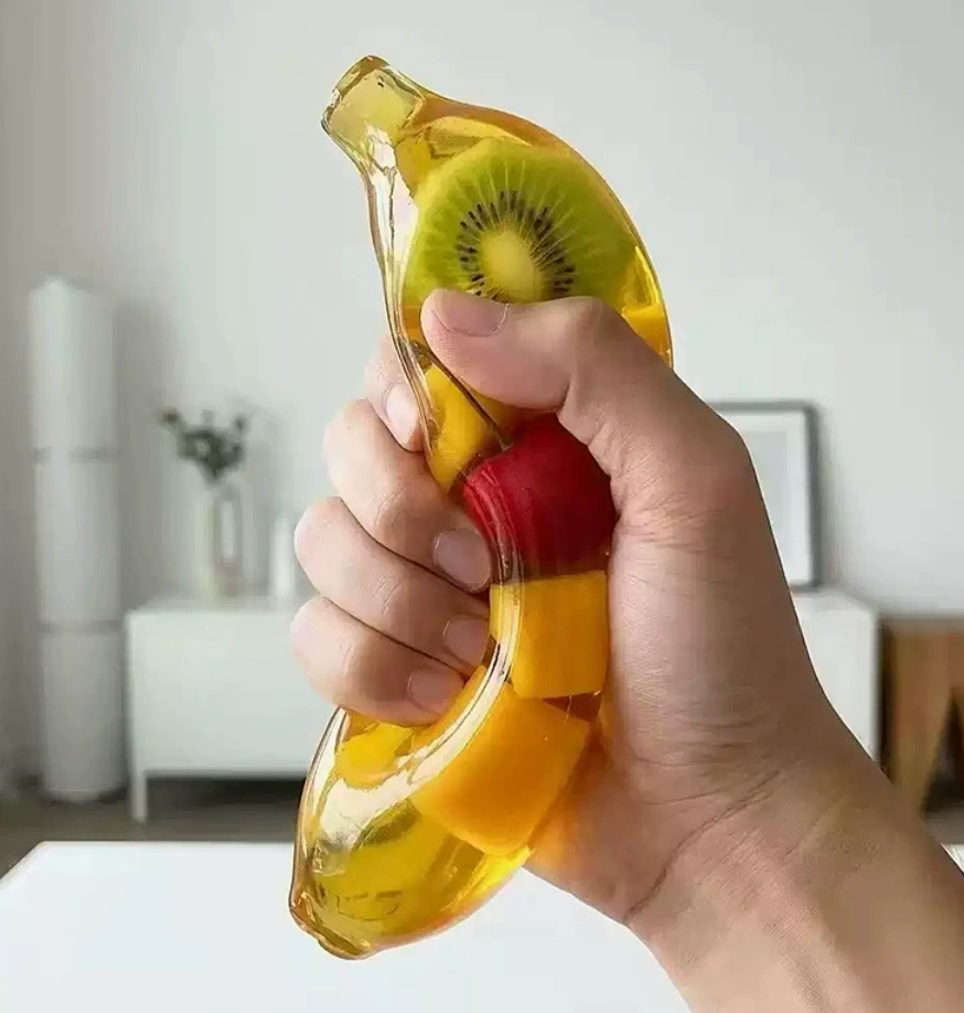 Banana-shaped fruit gel squishy compressed by hand
