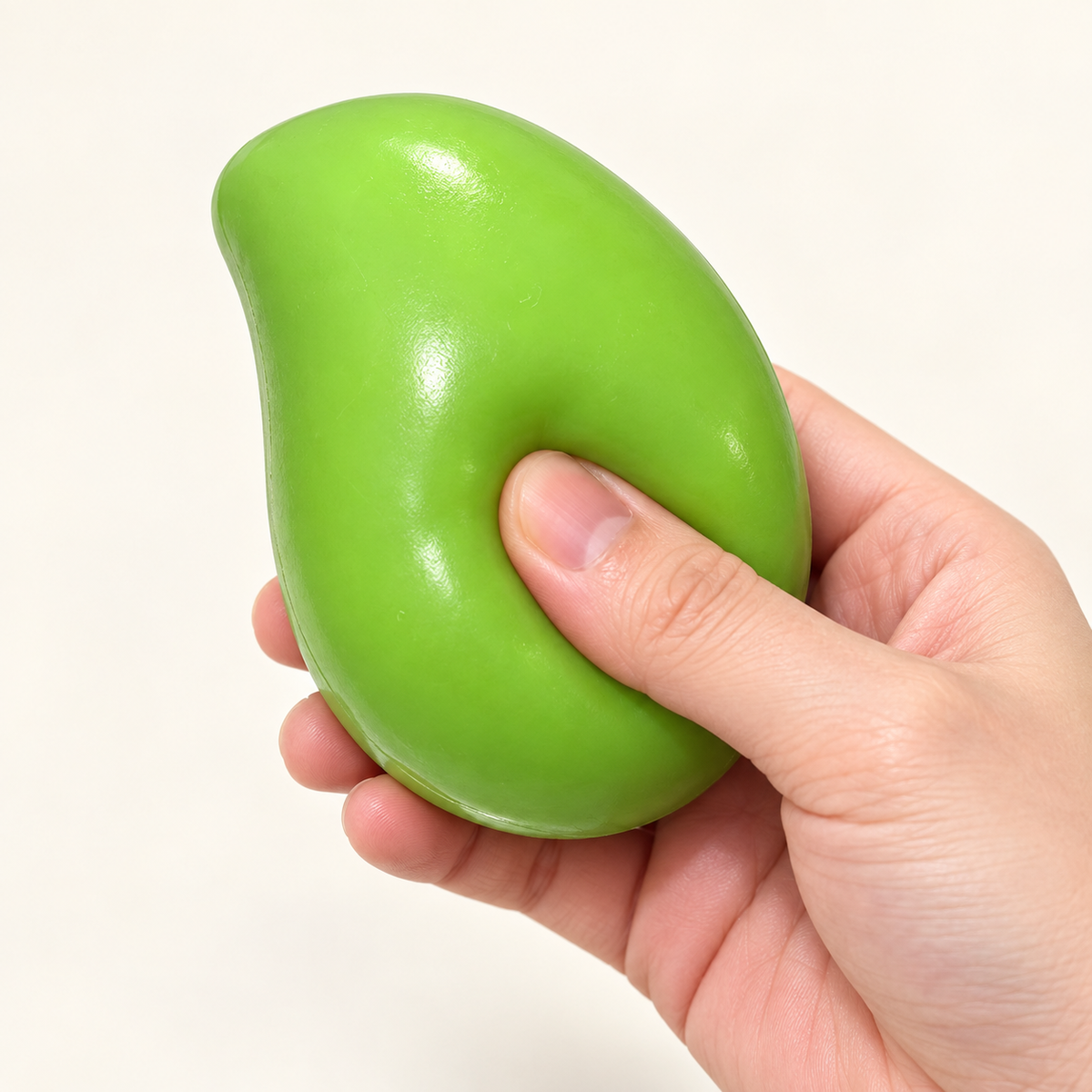 Illustration of a hand gently squeezing the green mango toy